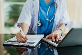 Dr Raghav Oza managing patient prescriptions and online consultations on his laptop
